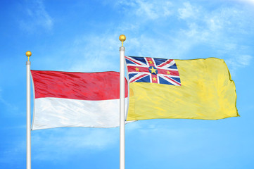 Indonesia and Niue two flags on flagpoles and blue cloudy sky