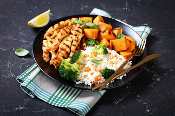 close-up of chicken strips, broccoli, rice, yams