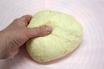 Hand kneads the dough. Close-up. The concept of cooking dough and baking.