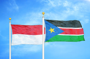 Indonesia and South Sudan two flags on flagpoles and blue cloudy sky