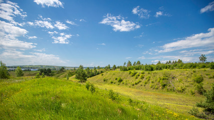 hills overgrown with trees and grass on a sunny day