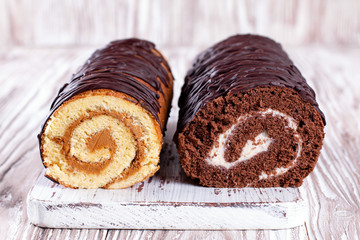 Two biscuit rolls. Chocolate and white cream sponge roll