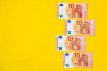 Euro banknotes on a yellow background. Top view. Copy, empty space for text