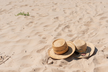 View of sandy beach with summer hats and sunglasses. Blank advertisement or packaging layout.