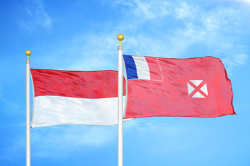 Indonesia and Wallis and Futuna two flags on flagpoles and blue cloudy sky