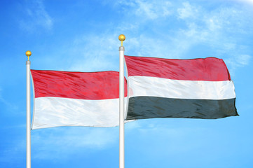 Indonesia and Yemen two flags on flagpoles and blue cloudy sky