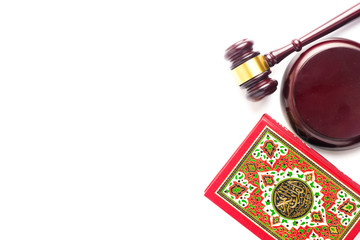 Flatlay picture of Quran with law gavel on white background for sharia or Islamic law concept. Large Arabic word mention the Holy Quran is with variance recitation and correct pronounciations method. - obrazy, fototapety, plakaty