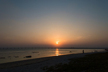 オレンジ色の夕日と飛行場の誘導灯とシルエットの人々