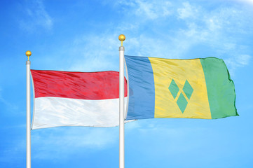 Indonesia and Saint Vincent and the Grenadines two flags on flagpoles and blue cloudy sky