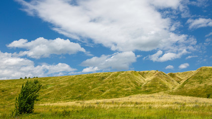 Fototapeta premium grass-covered hills above the valley on a sunny day