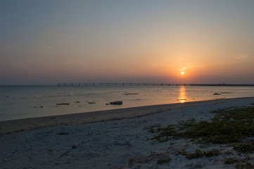 オレンジ色の夕日と飛行場の誘導灯と砂浜