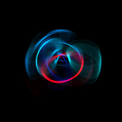 Spinning rays of light isolated on black background. Graphic 2D illustration of glowing colorful light particles in circular motion.