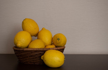 Fresh ripe lemons in wooden basket