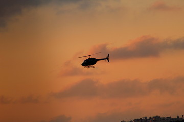Fototapeta na wymiar helicopter on the sunset orange sky