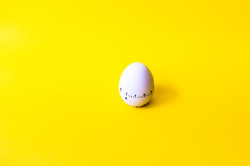 white egg timer on yellow background. Happy Easter in the kitchen. Home related, home staying. Free...