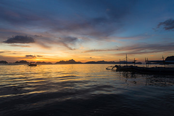 traditional philipinian boat silhouette in El Nido, Palawan with colored sunset on background