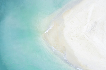 View from above, stunning aerial view of a white sand beach bathed by a beautiful turquoise sea. Tanjung Aan Beach, east of Kuta Lombok, West Nusa Tenggara, Indonesia.