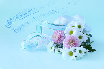 楽譜とパステルカラーのピンポンマムと白の小菊の花束（ブルーバック）
