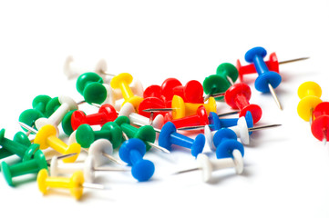 Multicolored push pins on white background close-up