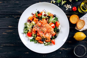 Red fish with fresh sliced vegetables on a white plate. Flat Lay