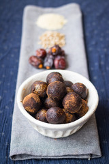 Black truffle chocolate energy protein sweet balls. Vegan cocoa dieting raw dessert. Ingredients - date fruits, sesame seeds, sunflower seeds. 