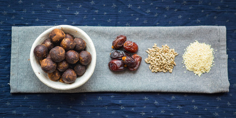 Black truffle chocolate energy protein sweet balls. Vegan cocoa dieting raw dessert. Ingredients - date fruits, sesame seeds, sunflower seeds. 
