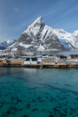 Famous little lonely island with yellow houses and cabins located in northern Norway. Surrounded by turquoise sea water and specific sharp snowy mountains.Usually over touristed place, now abandoned. 