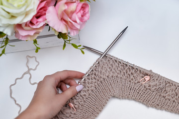 the beginning of knitting a cardigan on knitting needles