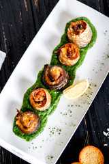 Fish rolls on spinach baked under cheese