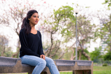 Obraz premium Young beautiful Persian woman relaxing at the park