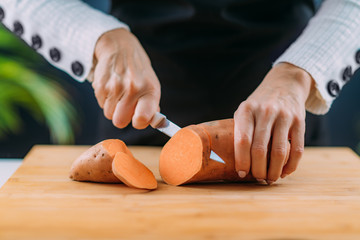 Cutting Fresh Organic Sweet Potato, superfood rich in tryptophan, potassium, vitamin C, phytonutrients and dietary fibers