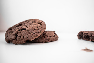 Two chocolate chip cookies on a white table