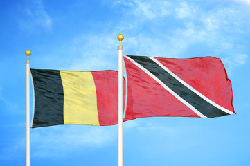 Belgium and Trinidad and Tobago two flags on flagpoles and blue cloudy sky