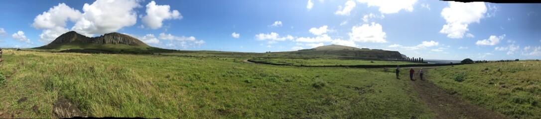 Fototapeta premium panorama of rolling green hills with blue sky and white clouds mid-day