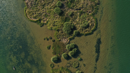 Aerial top down view of Thu Bon river with small round islets covered by green jungle grass on water. Beautiful landscape from drone.