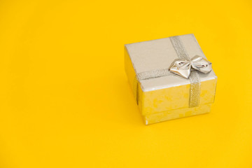 Silver gift box on yellow background. Copy, empty space for text