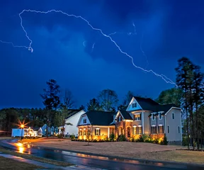 Fotobehang Powerful lightning storm front passes over residential houses © Stuart Monk