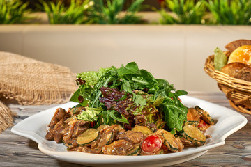 Hot snack. Warm salad of vegetables, herbs, meat