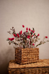 Beautiful branches of dried flowers in a small wicker basket on the large basket. Eco material.