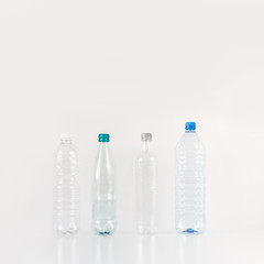 Four different plastic bottles standing on white background. Plastic waste