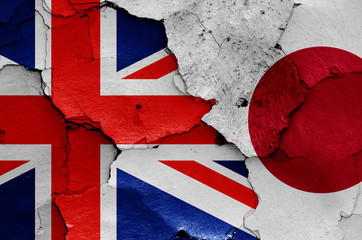 flags of UK and Japan painted on cracked wall