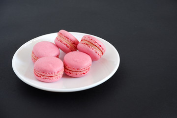 Macaroons on a black background. Sweets