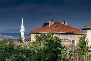Obraz premium White minaret from a mosque in the background of a village garden