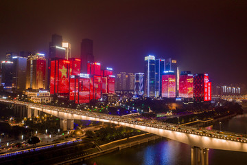 Fototapeta premium Aerial view of Huang Hua Yuan bridge over Jialing river by buildings with Chinese Flags on