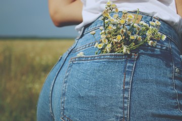 A close up of jeans with flowers in it's pocket