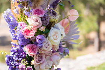 Decorative decoration of the wedding arch with fresh flowers. Holding a wedding ceremony in the open. Decoration details