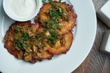Close up view on Traditional dish of Ukrainian cuisine - potato pancakes with sour cream and...