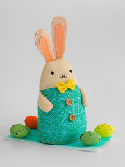 bunny and Easter eggs on a medical mask on white background. close up. celebrating Easter during the coronavirus..