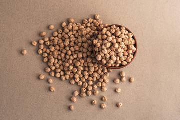 Raw dry chickpea grains in a brown clay bowl
