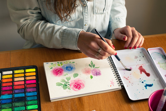 Lady painting roses with watercolor technique